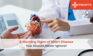 Doctor holding a heart model explaining heart disease warning signs